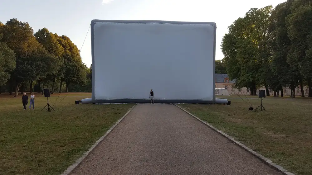 Projection cinématographique en plein air sur un écran gonflable de 15m par Hallucine, ambiance nocturne magique
