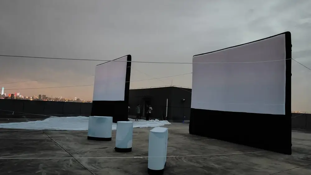 Écran de cinéma gonflable de nuit sur toit d'immeuble