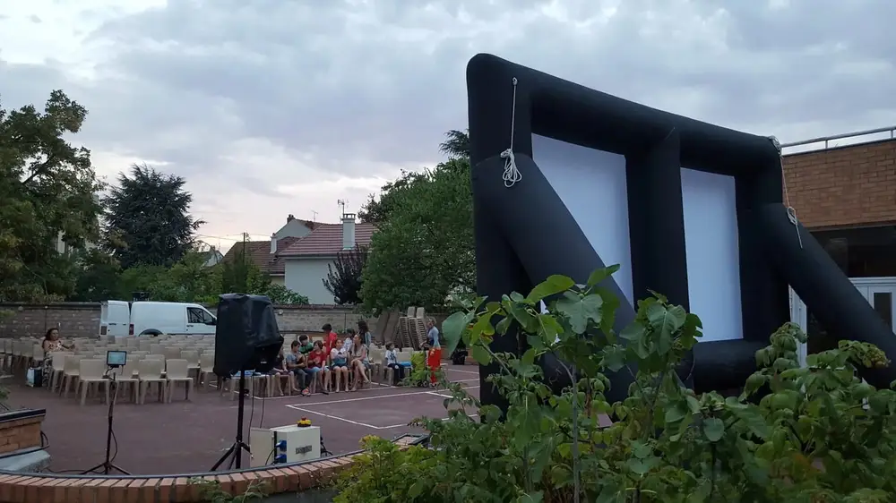 Projection d'un film en extérieur pour un petit groupe sur l'herbe
