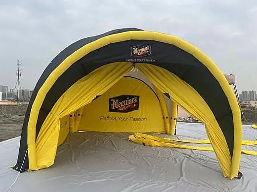 Tente araignée gonflable avec des parois latérales jaunes, créant un espace abrité