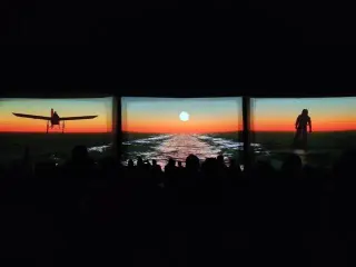 Three giant inflatable movie screens set up outdoors at sunset