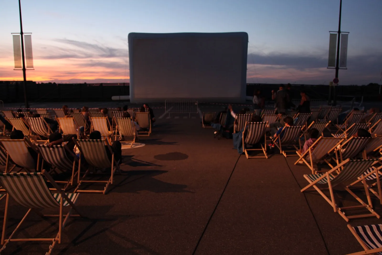 Séance de cinéma en plein air clé en main : écran gonflable Hallucine, transats et public